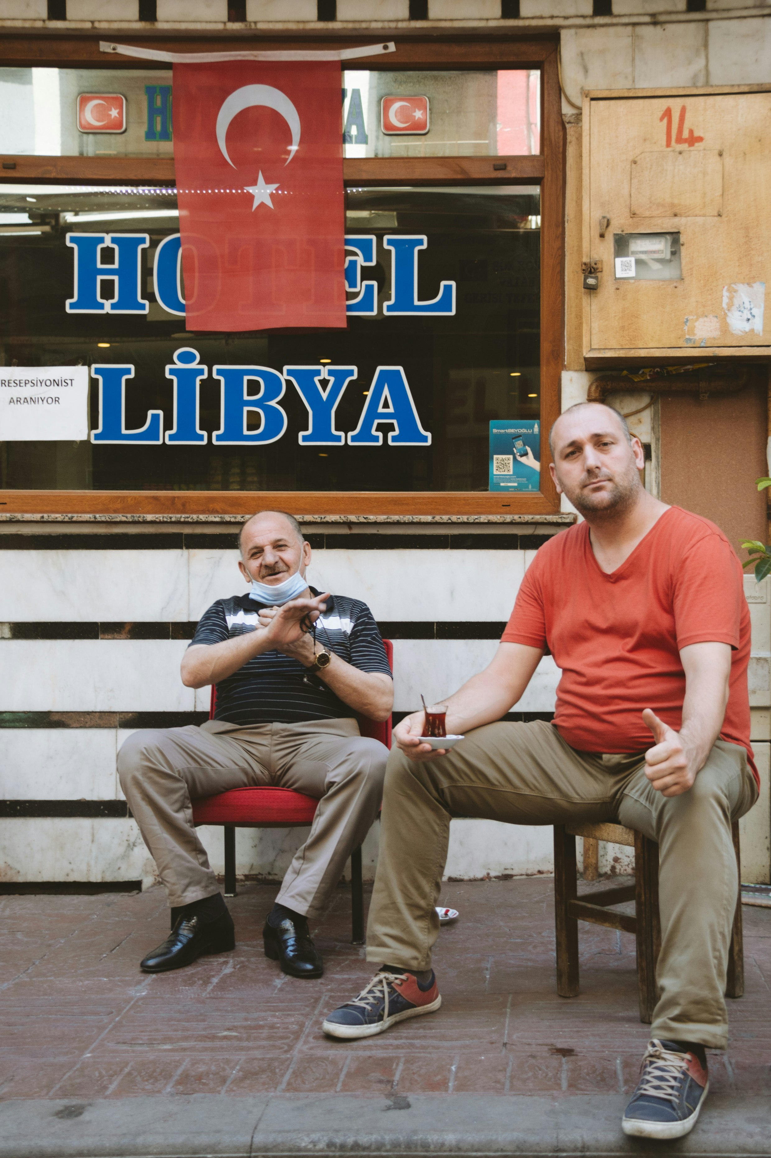 man in red crew neck t-shirt sitting on brown wooden bench